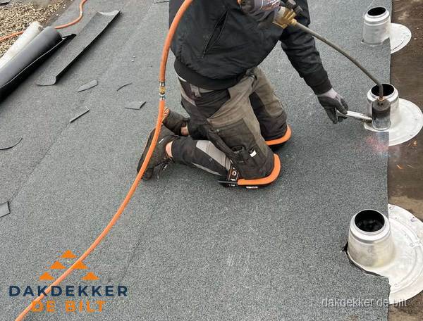 Dakdekker repareert bitumen dakleer bij dakdoorvoer in De Bilt