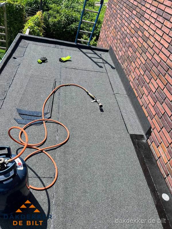 Plat dak met bitumen en brandgereedschap van dakdekkersbedrijf in De Bilt