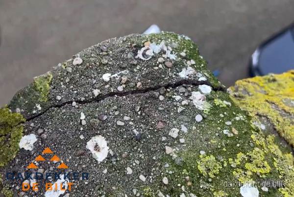 Beschadigde en verweerde nokvorst met scheuren en mos in De Bilt