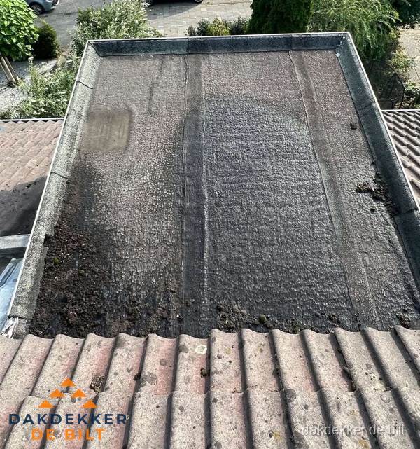 Verouderd plat dak met bitumen en slijtage voor lekkage inspectie in De Bilt