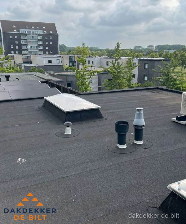 Groot plat dak met lichtkoepel en dakdoorvoeren in De Bilt