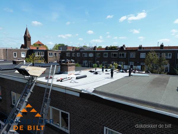 Dakdekkers aan het werk op plat dak in De Bilt