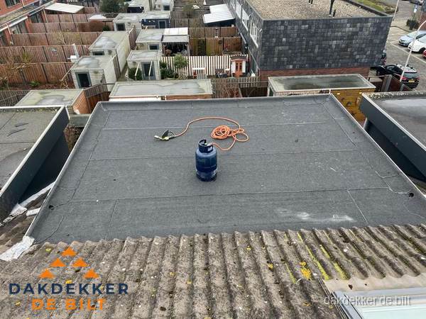 Plat dak met nieuwe bitumen dakbedekking en brandgereedschap in De Bilt