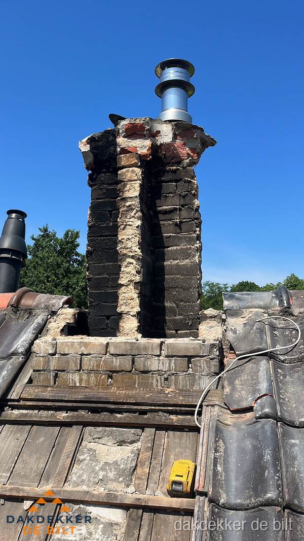 Beschadigde schoorsteen met nieuwe rookgasafvoer op oud dak in De Bilt