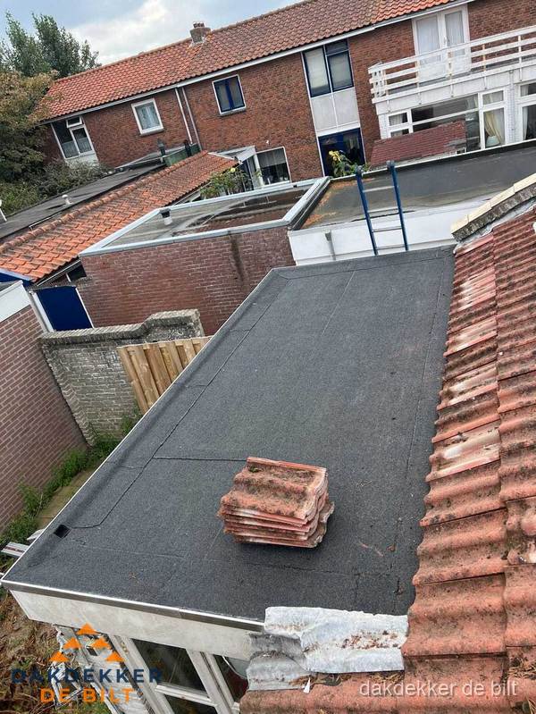 Plat dak aanbouw met bitumen naast schuin pannendak in De Bilt